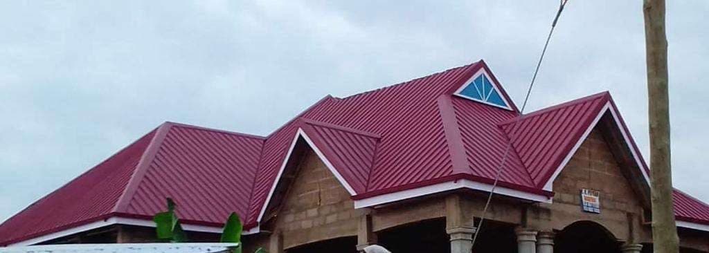 Completed maroon metal roof on a Ghanaian home